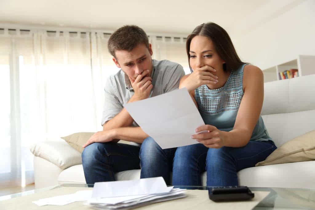 Couple reviewing car accident insurance policy after completing the first steps in their car accident checklist.